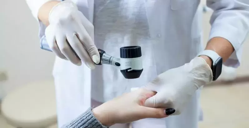 Pacient z bradavicami na diagnostičnem pregledu pri dermatologu